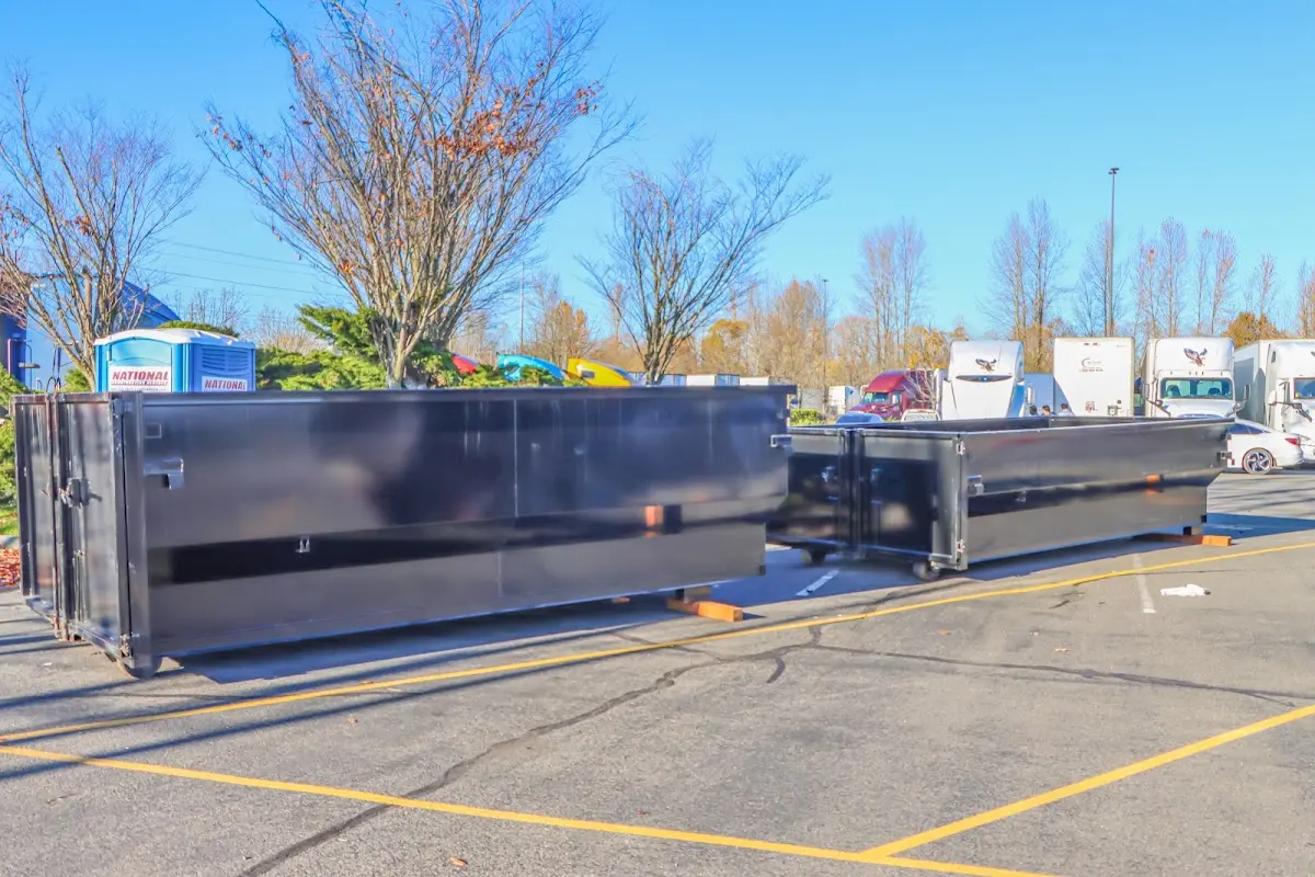 Professional dumpster rental service with roll-off container on residential driveway in Ada